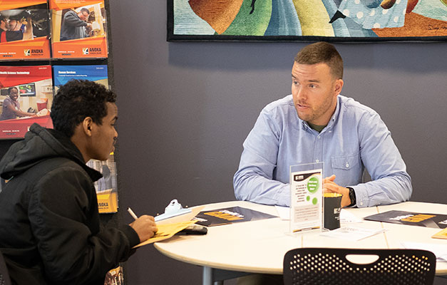 Student meeting with an enrollment coach in the admissions office.  