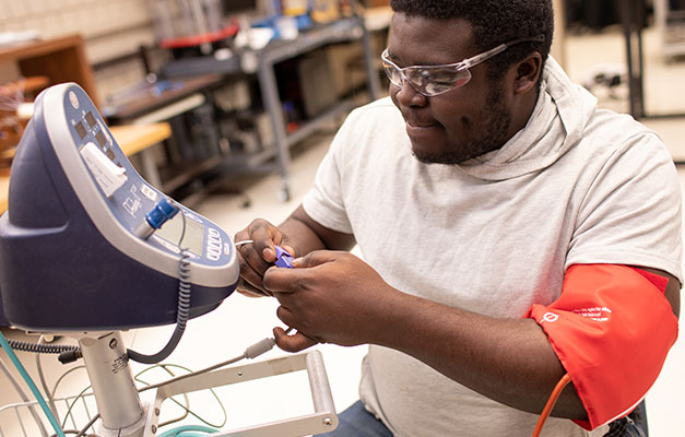 A Student Working on a Machine. 