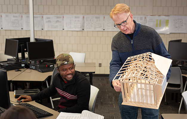 A Student and Professor Looking at a 3D Model. 