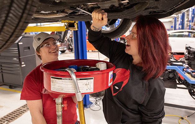 Two Students Working on a Car in the Lab. 